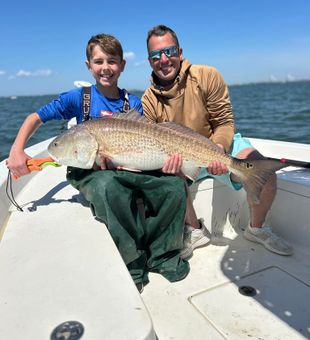 Teaching young kid how to reel trophy redfish