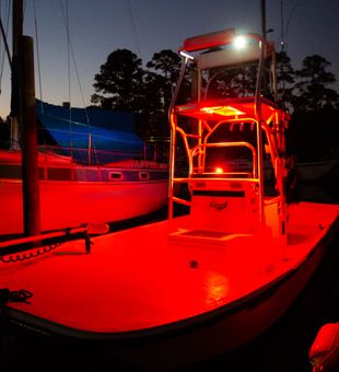 Red lights illuminate the fishing boat at Bagdad FL marina.