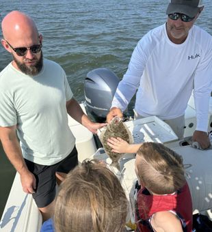 Hands-on flounder catch on a Somers Point NJ family fishing charter