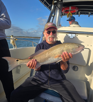 Reeling in a big one on a beautiful day out on the water.