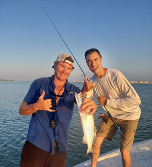Happy anglers with a feisty speckled trout!