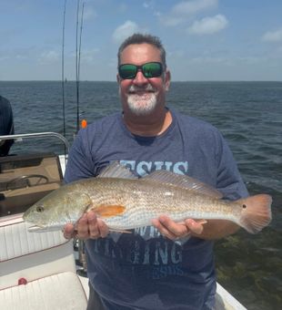 Fresh redfish catch, bright day on the water.