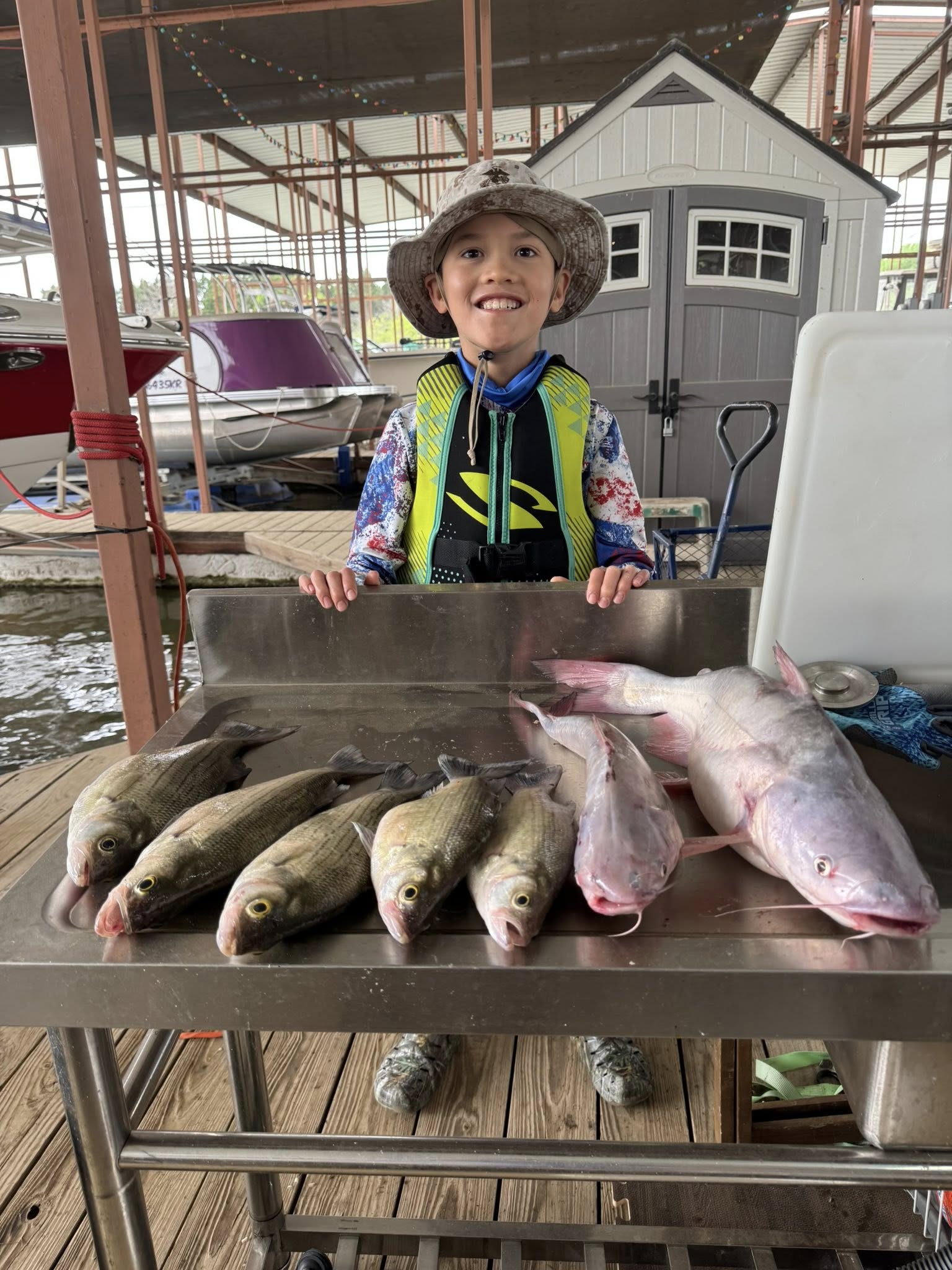 Happy Levi with hefty striped bass and catfish!