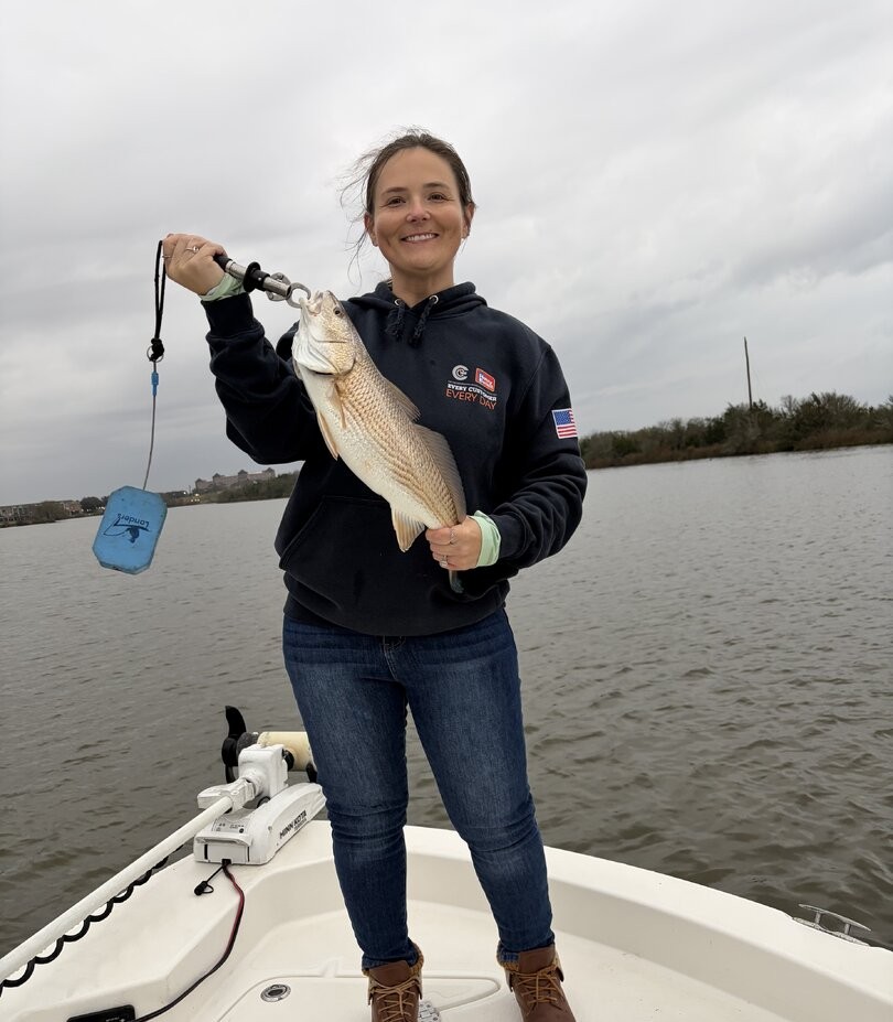 Landing a powerful Texas redfish on a beautiful day of inshore fishing along the Gulf Coast.
