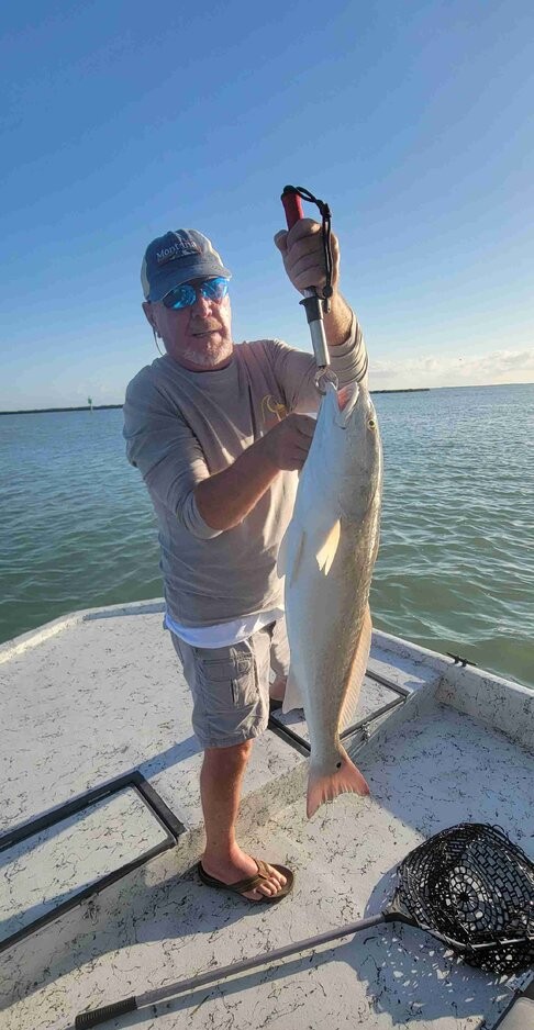 Reeling in redfish and speckled trout on a sunny fishing trip in South Padre Island, TX.