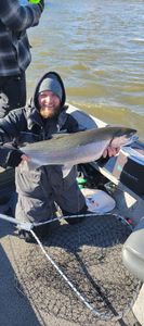 Angler with a large rainbow trout caught while fishing in MI