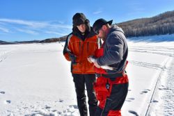 Ice fishing preparation on frozen lake in Rifle Colorado with winter gear and equipment