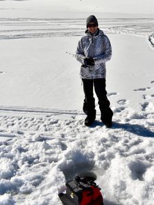 Ice fishing setup on frozen lake in Rifle Colorado with fishing rod and gear bag