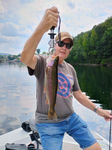 A fisherman holding a rainbow trout in Branson