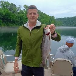 Angler holding a rainbow trout in Branson