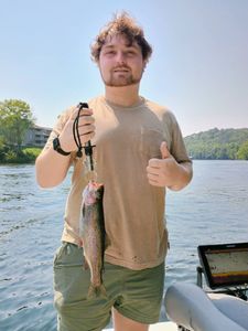Angler catching a rainbow trout in the great outdoors of MO
