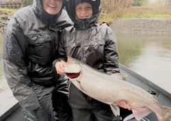 Happy coho salmon catch on rainy river fishing trip