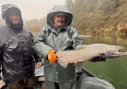 Two anglers holding large Chinook salmon caught while fishing in Port Orford OR