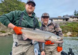 Two anglers holding large Chinook salmon catch in Port Orford OR