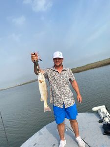 A fisherman holding a large redfish in Rockport