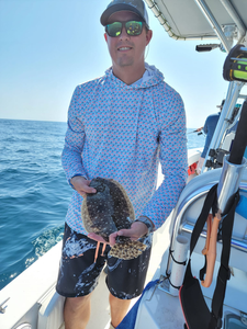 Scenic view of Oak Island with a single summer flounder caught by fishermen