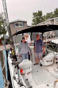 Three people enjoying a day of fishing by the lakeside in Marblehead