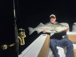 A person fishing for a striped bass in Wells