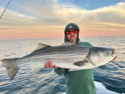 A person fishing for a striped bass in Wells