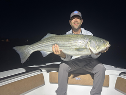 Huge striped bass reeled in as clouds roll in!