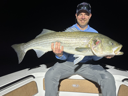 Reeling in a huge 37-inch striped bass as clouds roll in!