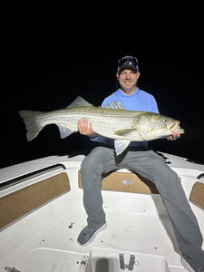 Reeling in a huge 39-inch striped bass as clouds roll in!