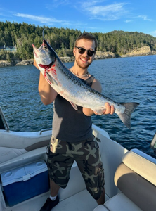 Angler holding a fish on the shore in BC
