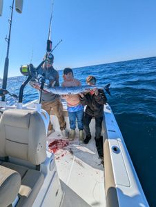 Fishing charter boat in Port Orange FL with large barracuda catch displayed on deck