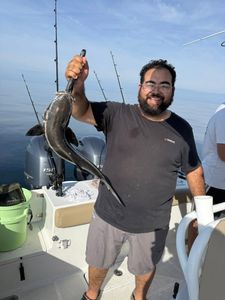 Angler holding freshly caught eel on fishing boat in Port Orange FL