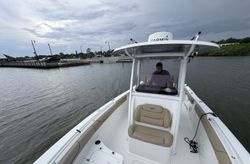 White fishing boat with center console and T-top on calm water in Port Orange FL marina