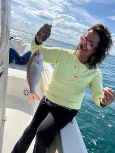 Angler holding freshly caught fish on boat in Port Orange FL waters