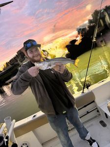 Angler holding caught snook fish on boat during sunset in Port Orange FL