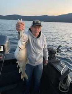 A fisherman holding a 20-inch fish in Tahoe Vista