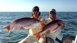 Two anglers reeling in their catch on a fishing trip in FL