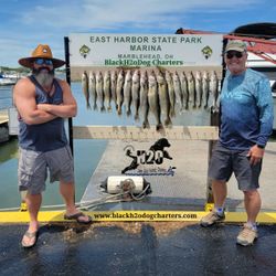 Three anglers reeling in their fishing line at the lakeside in Marblehead