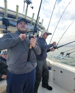 Three people enjoying a lakeside fishing trip in Marblehead