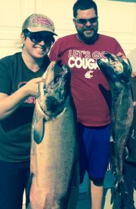 Two anglers fishing in Washington, reeling in a big catch