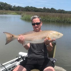 Angler holding a large redfish caught while fishing in GA