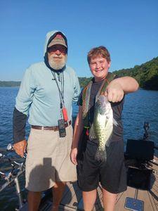 Two anglers holding a white crappie in Arkansas