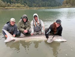 A group of 4 people fishing for white sturgeon in BC