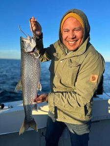 A fisherman holding a large lake trout in Manistee