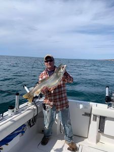 Angler standing in water holding a 21-inch fish in MI