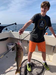A single fisherman in Manistee, holding a fishing rod while fishing