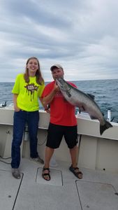 Two people fishing in Manistee, Michigan with a 24-inch fish