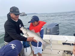 Big Striped Bass hooked while deep sea jigging in partly cloudy Hingham!