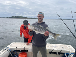 Reeling in a big Striped bass at the Shipyard after a day of deep sea, jigging, and trolling!