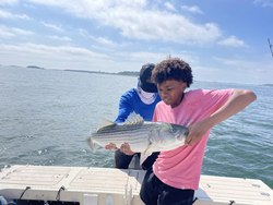 Reeled in a massive striped bass while tackling the deep blue seas around Boston!