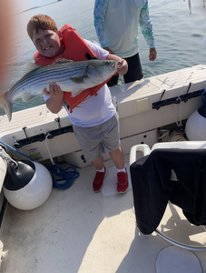 Reeling in a striped bass on a partly cloudy day in Hingham!