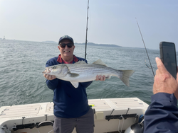 Big Striped Bass landed in Hingham's partly cloudy waters!