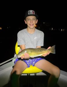 A fisherman holding a large redfish caught in FL